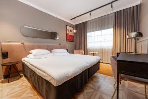 a hotel room with a bed and a desk at Original Sokos Hotel Vaakuna Pori in Pori