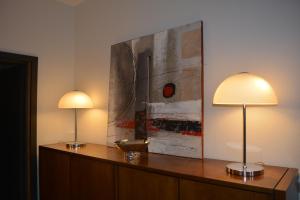 two lamps on a desk with a painting on the wall at Appartement-terrasse parking privé Meublé de Tourisme 4 étoiles in Belfort