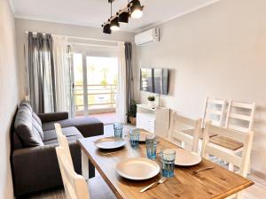 a dining room and living room with a wooden table at Mediterranean Way - Pineda 1 in La Pineda