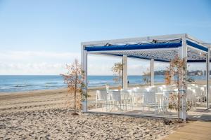 a gazebo on the beach with tables and chairs at Mediterranean Way - Pineda 1 in La Pineda