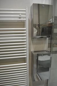 a bathroom with a toilet and a glass cabinet at Appartement-terrasse parking privé Meublé de Tourisme 4 étoiles in Belfort
