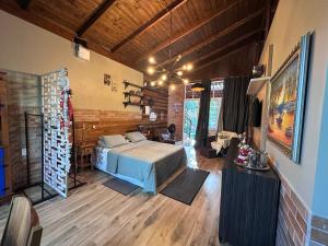 ein Schlafzimmer mit einem Bett in einem Zimmer mit Holzboden in der Unterkunft Arthi - LINDO LOFT RECANTO DOS PASSARINHOS in Balneário Camboriú