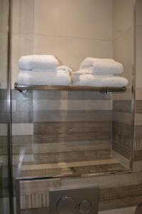 a glass display case with towels on a shelf at Appartement-terrasse parking privé Meublé de Tourisme 4 étoiles in Belfort
