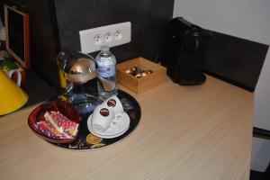 a table with a tea kettle and a bowl of candy at Appartement-terrasse parking privé Meublé de Tourisme 4 étoiles in Belfort