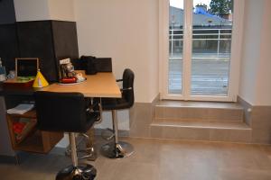 a room with a table and two chairs and a window at Appartement-terrasse parking privé Meublé de Tourisme 4 étoiles in Belfort