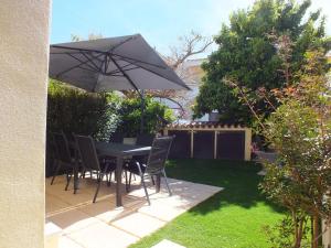 a table and chairs under an umbrella in a yard at Casa Budoni gemütliche Ferienwohnung Zentral doch ruhig gelegen 1km vom Strand in Budoni
