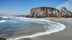 una vista aerea di una spiaggia con formazione rocciosa di APARTAMENTO SOLAR DA PRAÇA, Aconchegante e Climatizado a Torres