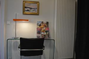 a glass table with a chair and a lamp at Appartement-terrasse parking privé Meublé de Tourisme 4 étoiles in Belfort