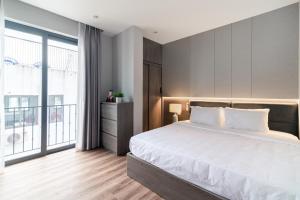 a bedroom with a large bed and a large window at Luxe Paradise Suites Hotel To Ngoc Van in Hanoi +67 photos