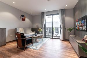 a living room with a couch and a table at Luxe Paradise Suites Hotel To Ngoc Van in Hanoi