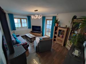 a living room with a couch and a tv at Ferienwohnung beim Maler Gandi in Kienberg