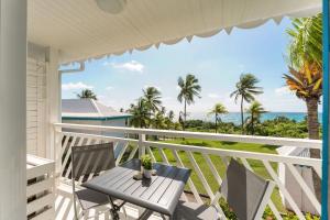 a balcony with a table and chairs and the ocean at Le PARADIS BLEU VUE MER in Saint-François