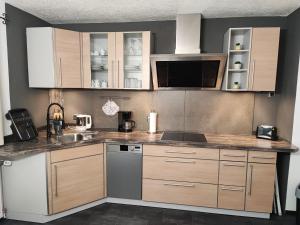 a kitchen with wooden cabinets and a counter top at Ferienwohnung beim Maler Gandi in Kienberg