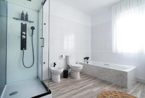 Un baño con bañera, inodoro y ducha. en GALIHOST - Casa de Cruces, en Villanueva de Arosa 39 fotos más