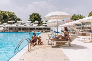 a group of people sitting in the pool at a resort at Porto Giardino - CDSHotels in Monopoli +61 photos