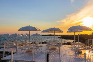a group of chairs and umbrellas on a dock on the water at Grand Hotel Riviera - CDSHotels in Santa Maria al Bagno