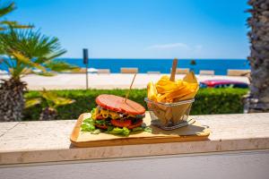 a sandwich and chips on a table next to the beach at Grand Hotel Riviera - CDSHotels in Santa Maria al Bagno