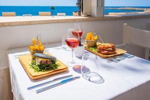 a table with two plates of food and glasses of wine at Grand Hotel Riviera - CDSHotels in Santa Maria al Bagno