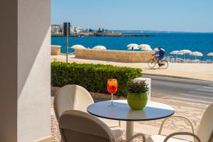 a table with a glass of wine sitting on a balcony at Grand Hotel Riviera - CDSHotels in Santa Maria al Bagno