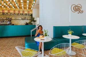 a woman sitting at a table in a restaurant at Grand Hotel Riviera - CDSHotels in Santa Maria al Bagno