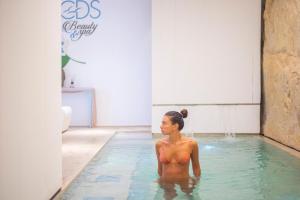 a woman sitting in a pool of water at Grand Hotel Riviera - CDSHotels in Santa Maria al Bagno