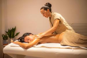 a woman getting a back massage on a bed at Grand Hotel Riviera - CDSHotels in Santa Maria al Bagno