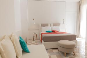 a white bedroom with a bed and a chair at Grand Hotel Riviera - CDSHotels in Santa Maria al Bagno