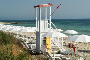 a row of chairs and umbrellas on a beach at Relais Masseria Le Cesine - CDSHotels in Vernole +84 photos