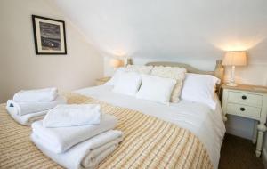 a bedroom with a bed with white towels on it at Bardristane Forge in Gatehouse of Fleet