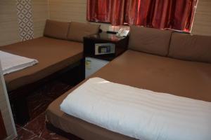 um pequeno quarto com 2 camas e uma janela em Everest Base Camp Hostel em Hong Kong