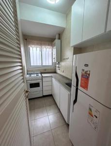 Elle comprend une petite cuisine avec un réfrigérateur et une fenêtre. dans l'établissement Departamento de 2 ambientes a estrenar a pasos de la playa, à Mar del Plata