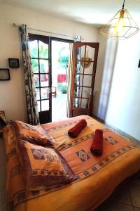 a bedroom with a large bed with red pillows on it at Chambre chez l'habitant clim piscine wifi in Saint-Pierre