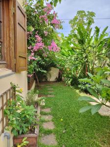 a garden with pink flowers and a walkway at Chambre chez l'habitant clim piscine wifi in Saint-Pierre +6 photos