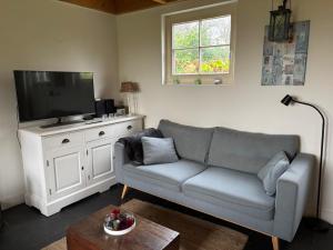 a living room with a couch and a flat screen tv at Holiday home Vossennest in Veere