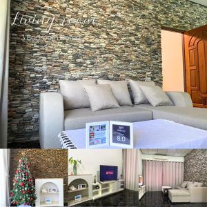 Una sala de estar con un sofá y un árbol de Navidad. en ชรัส รีสอร์ท เกาะล้าน, en Ko Sak