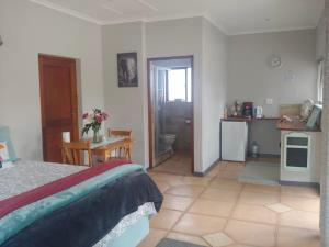 克尼斯纳Hope Cottage- No smoking allowed on property的一间带床、桌子的卧室和一间厨房