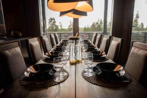 een lange houten tafel met glazen en borden erop bij Villa Aspen D Ski-in Ski-out by Aavalevi in Levi +16 foto's