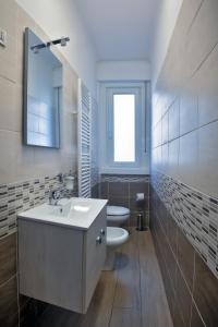 um banheiro com uma pia, um vaso sanitário e uma janela em Home Istria 81 em Trieste