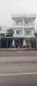 a building with tables and umbrellas next to a street at Port Hotel, Tasucu in Silifke
