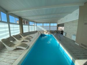 a large swimming pool with lounge chairs in a building at Hotel Howard Johnson Rosario in Rosario