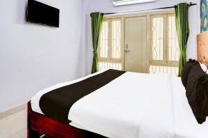 a bedroom with a white bed and a window at Hotel O Green Banjara Stay in Hyderabad