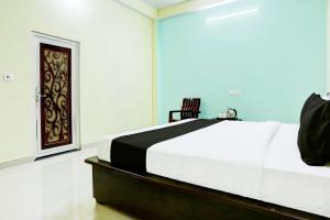 a bedroom with a large white bed with a door at Hotel O Galaxy in Chaukhandi