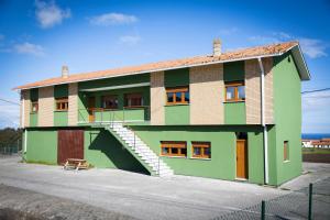 a green building with stairs on the side of it at Playa del Silencio 1 in Castañeras