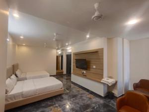 AmbajiArihant Hotel的有两张床和一台电视的酒店房间