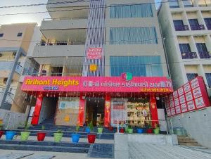 AmbajiArihant Hotel的大楼前有粉红色标志的商店 更多8张照片