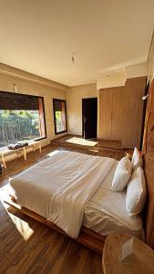 a bedroom with a large bed with a large window at Villa M Piscine chauffée, Hammam sans vis à vis Marrakech in Marrakesh