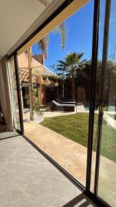 a sliding glass door of a house with a yard at Villa M Piscine chauffée, Hammam sans vis à vis Marrakech in Marrakesh