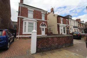 una casa de ladrillo en una calle con una pared de ladrillo en Ridge House, en Rotherham Road