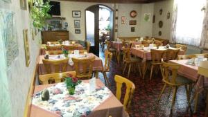 a restaurant with tables and chairs in a room at Pension Arnold Neuenburg in Neuenburg am Rhein