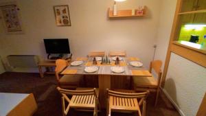 Un comedor con mesa y sillas y un televisor. en Studio Isola 2000, en Isola 2000 1 foto más